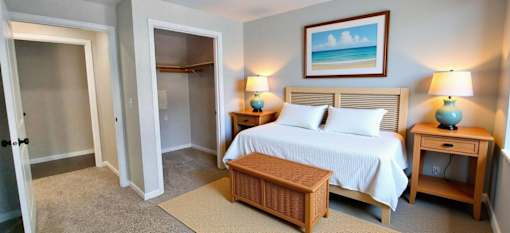 A bedroom with a bed, nightstands, and a painting on the wall.