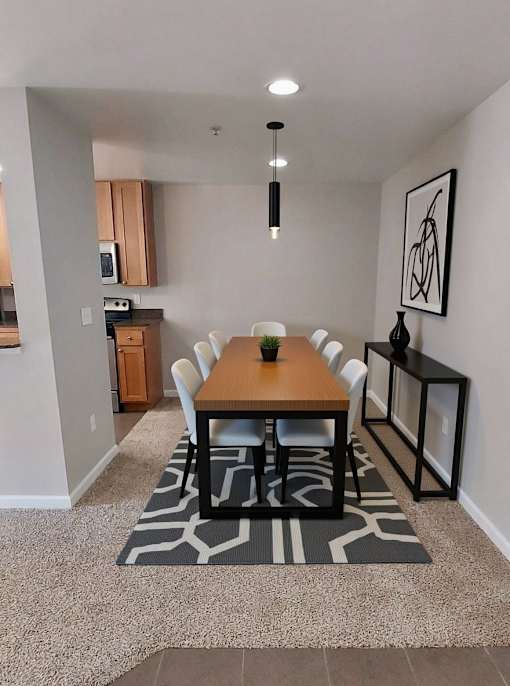 A dining room with a wooden table and chairs.