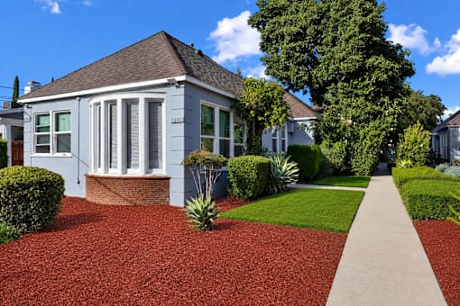 A house with a red gravel driveway and a concrete walkway.