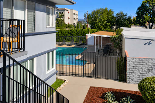A small pool in a backyard surrounded by a black fence.