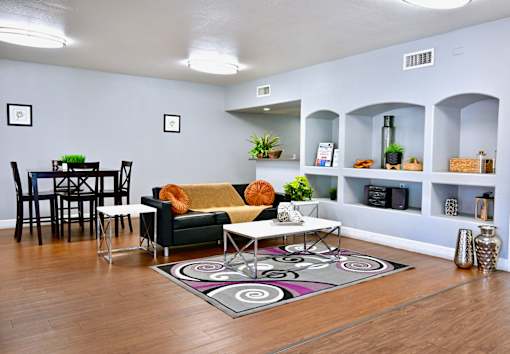 A living room with a black and white rug and a green couch.