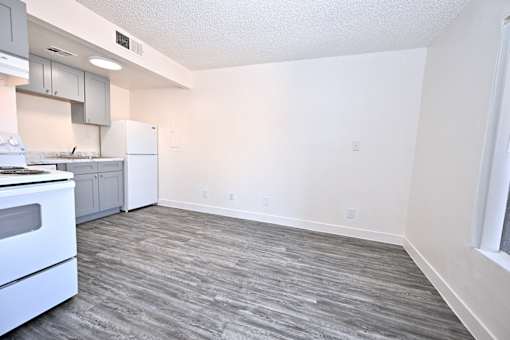 A kitchen with a white oven and a grey floor.