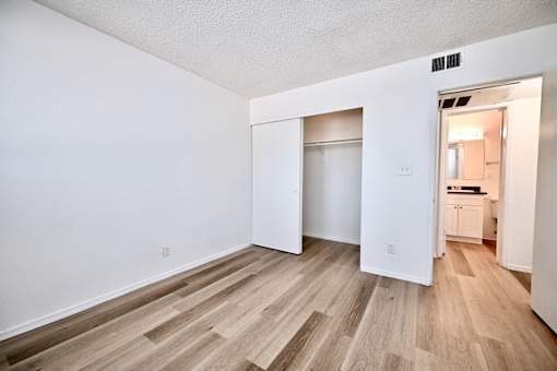 A room with a white wall and a wooden floor.