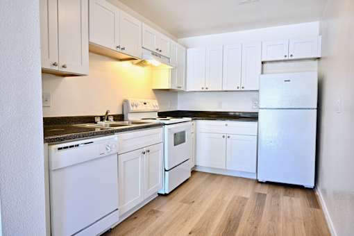 A kitchen with white appliances and cabinets.