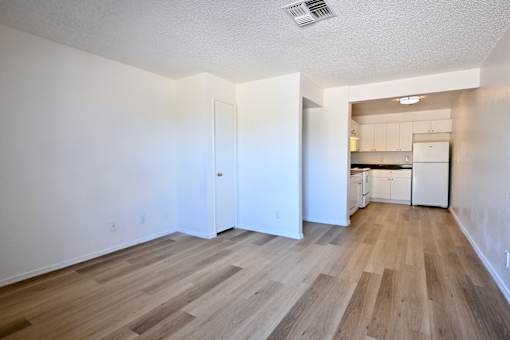 A room with wooden flooring and white walls.