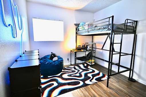 A room with a bunk bed and a bean bag chair.