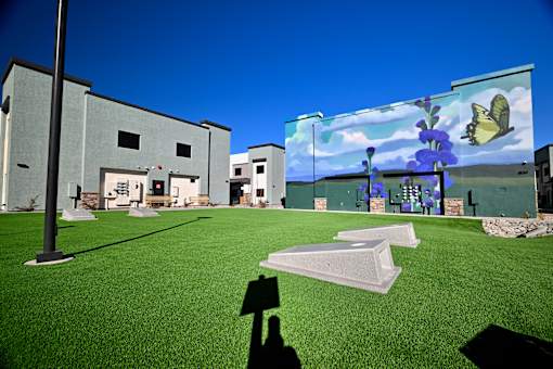 A person is holding a shadow of a person in front of a building.