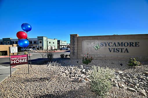 A sign that says "Sycamore Vista" is in front of some buildings.