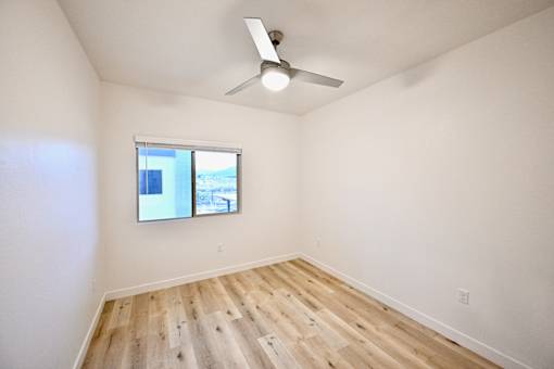 A room with a window and a ceiling fan.