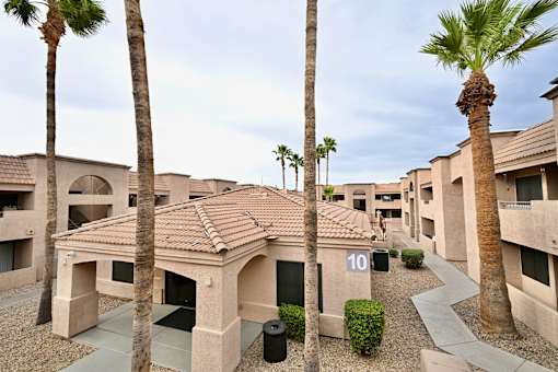 A building with palm trees in front of it.