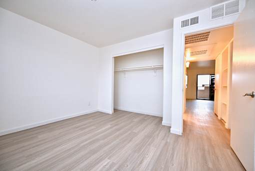 A room with a white wall and a wooden floor.