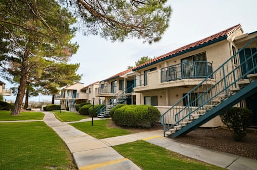 A row of apartment buildings with green railings and staircases.