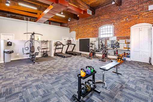 A gym with a variety of equipment including weights and exercise machines.