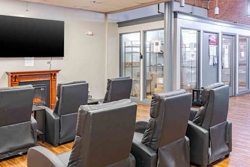 A room with a row of chairs and a television mounted on the wall.