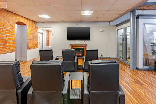 A room with a brick wall and a television mounted on it.