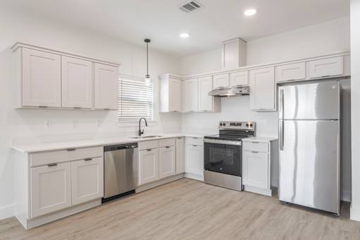 A modern kitchen with stainless steel appliances and white cabinetry.
