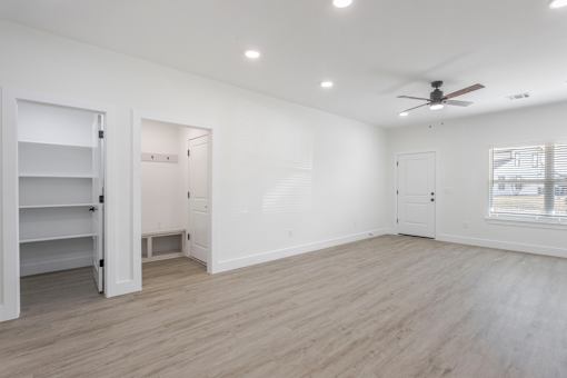 A spacious room with a ceiling fan and lighting fixtures.