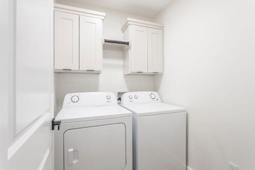 A white laundry room with a washer and dryer.