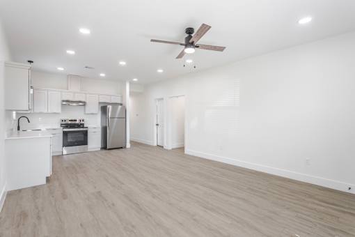 A spacious room with a ceiling fan and lighting fixtures.