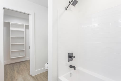 A white bathroom with a toilet and a walk-in shower.