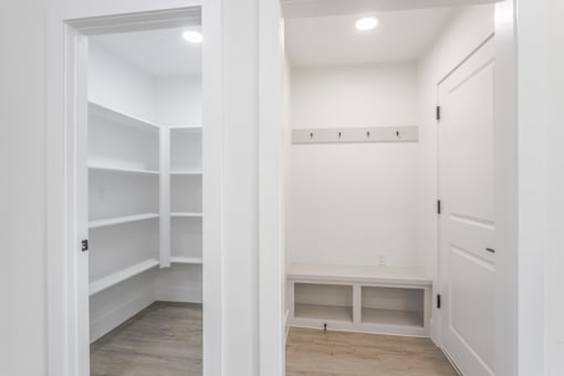 A white pantry with shelves and cabinets.