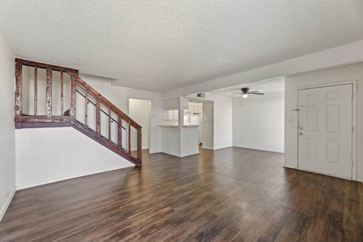 A room with wooden floors and a staircase with wooden railings.