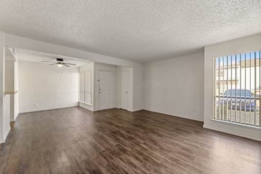 A room with wooden flooring and a ceiling fan.