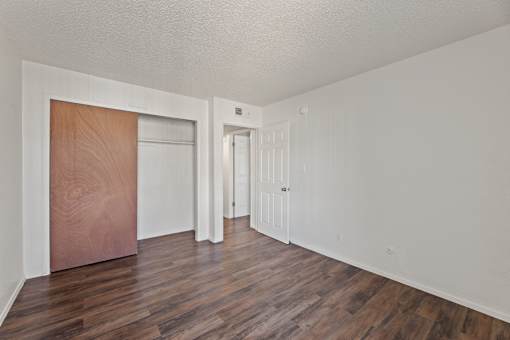 A room with a white wall and a brown door.