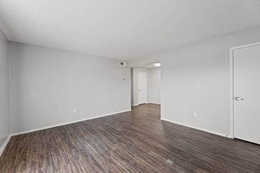 A room with wooden flooring and white walls.