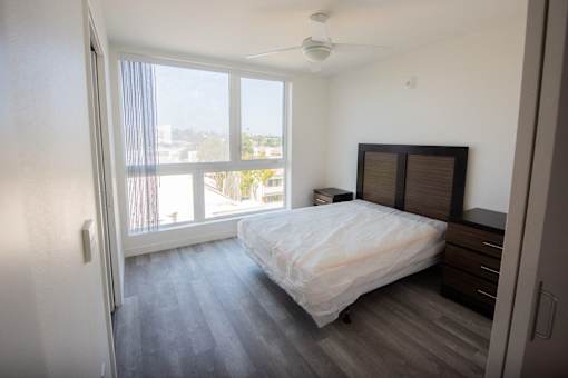 an empty bedroom with a bed and a window
