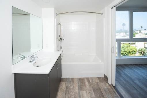 a bathroom with a sink and a shower near a window