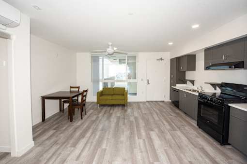 an empty living room with a kitchen