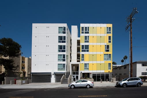 a white and yellow building on a city street with cars