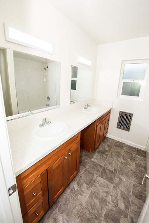 A bathroom with a sink, mirror, and cabinets.