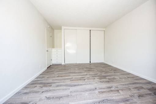 A room with a white door and a grey floor.