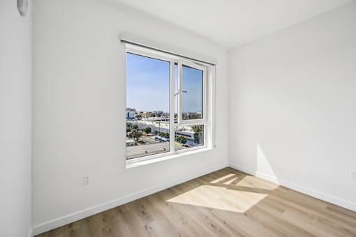A room with a large window overlooking a cityscape.