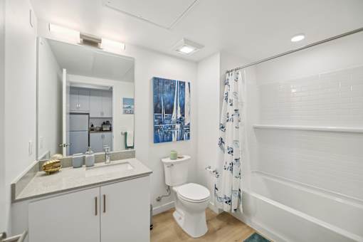 A white bathroom with a toilet, sink, and shower.
