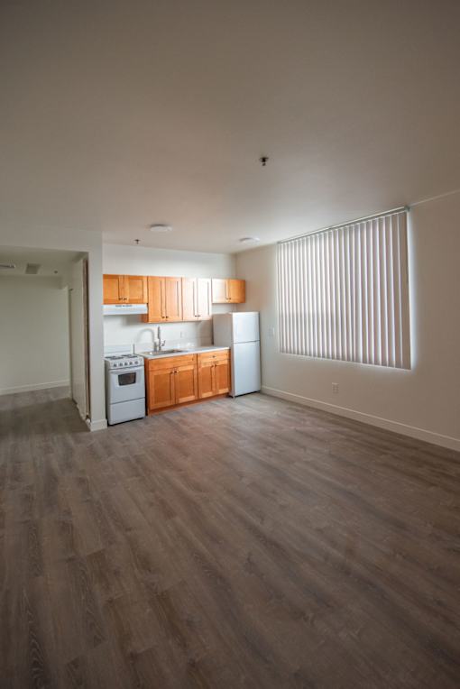 A kitchen with wooden floors and white appliances.