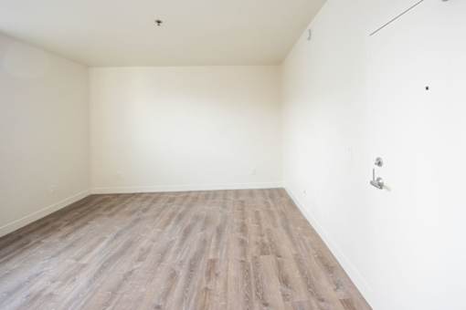 A room with wooden flooring and white walls.