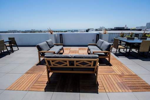 A wooden table and chairs are set up on a rooftop patio.