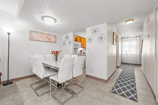 A dining room with a white table and chairs.