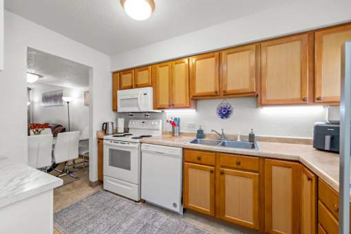 A kitchen with wooden cabinets and white appliances.