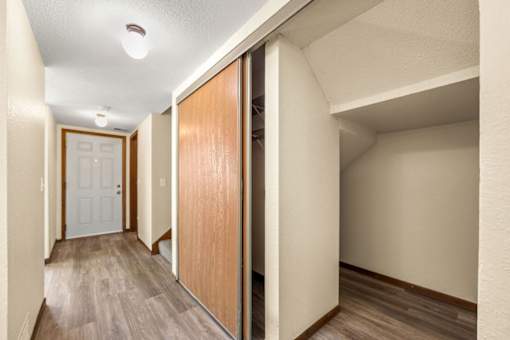 A hallway with a white door and a brown door.