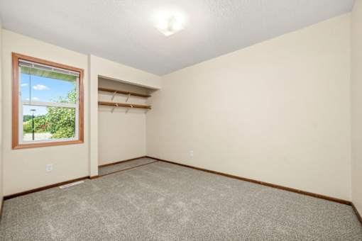A room with a window and carpeted floor.