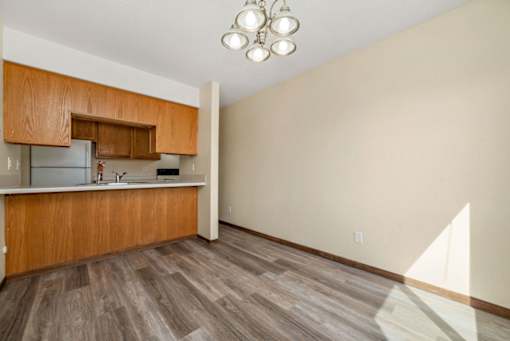 A kitchen with wooden cabinets and a refrigerator.