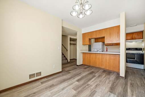 A kitchen with wooden cabinets and a stainless steel refrigerator.