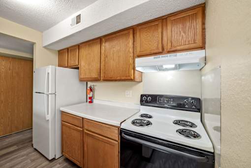 A kitchen with a white refrigerator and a white stove top oven.