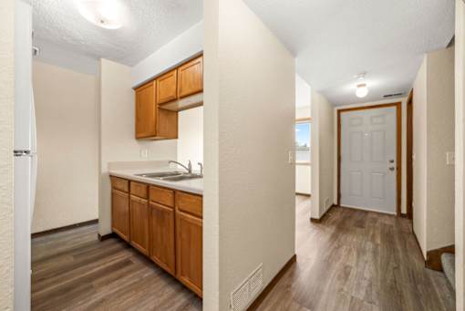 A kitchen with wooden cabinets and a white door.