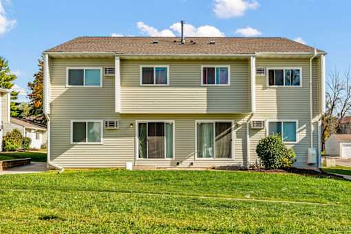 A two-story house with a brown roof and beige siding.