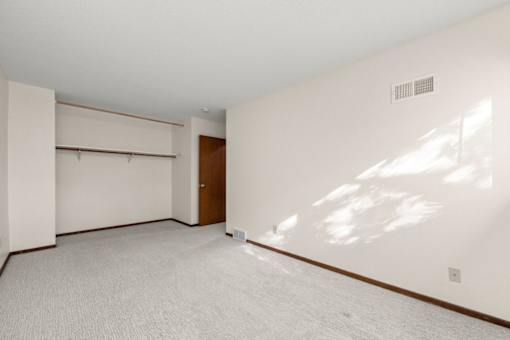 A large empty room with a door and a window.